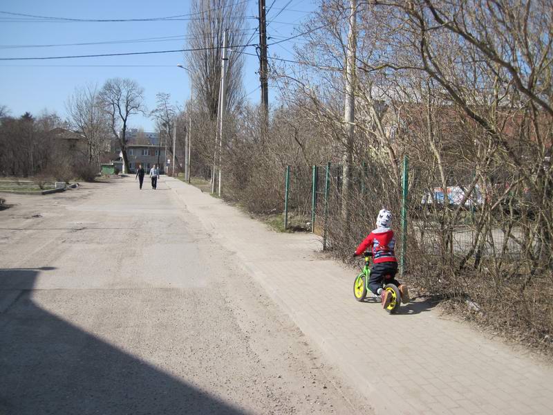 Мальчик на беговеле движется парралельным курсом